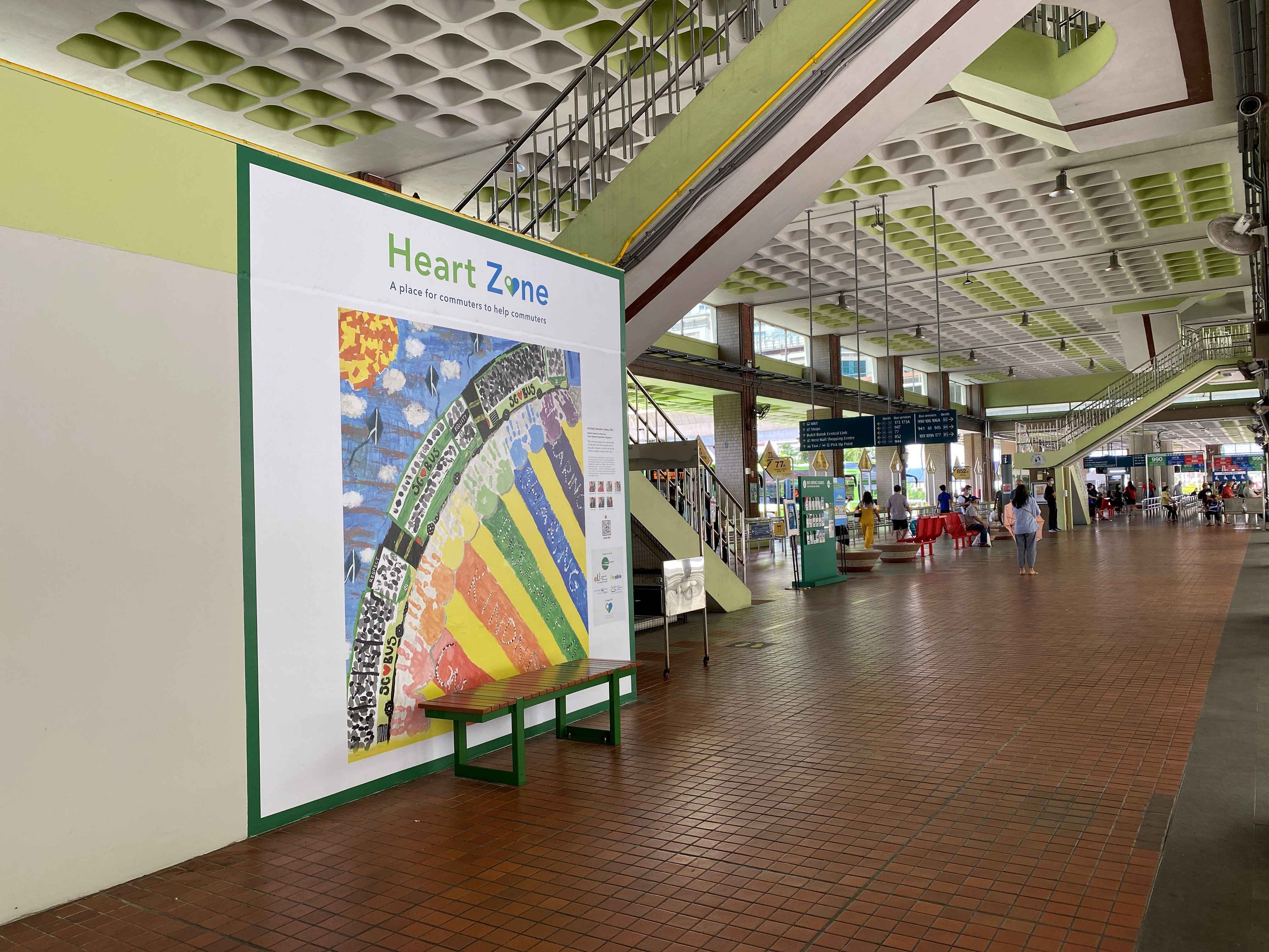 Heart Zone wall at Bukit Batok Bus Interchange displaying a colorful rainbow artwork with seating nearby.